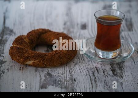 Türkischer Bagel simit und traditioneller türkischer Tee auf dem Holztisch, in der Nähe Stockfoto