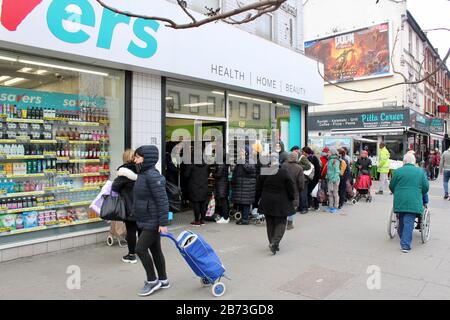 Warteschlange von Leuten, die darauf warten, Toilettenpapier zu kaufen, grüne Hochstraße, london UK Savers Chemiker Stockfoto