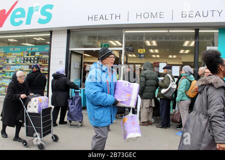 Warteschlange von Leuten, die darauf warten, Toilettenpapier zu kaufen, grüne Hochstraße, london UK Savers Chemiker Stockfoto