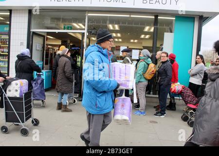 Warteschlange von Leuten, die darauf warten, Toilettenpapier zu kaufen, grüne Hochstraße, london UK Savers Chemiker Stockfoto