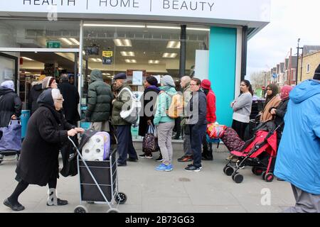 Warteschlange von Leuten, die darauf warten, Toilettenpapier zu kaufen, grüne Hochstraße, london UK Savers Chemiker Stockfoto