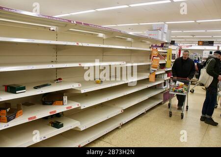 sainsburys haringey london; Käufer und leere Regale; toilettenrollen, Nudelwaren, die durch den Panikkauf des öffentlichen UK england ausverkauft wurden Stockfoto