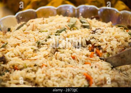 Kamerunische Jellof von Jollof Reis auf dem Buffet-Tisch bei einer Party zum Mittagessen. Enthält Reis und eine Vielzahl von Gemüse. Stockfoto