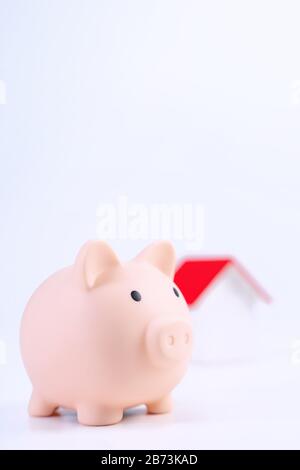 Finanzklage - Piggy Bank, wunderschönes rot-weißes Holzhausmodell auf weißem Hintergrund, spart Geld beim Kauf von Versicherungen, Nahaufnahme, Kopierplatz. Stockfoto