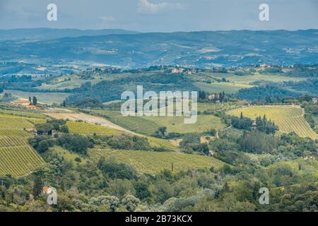 Toskanische Landschaft mit sanften Hügeln, Weinbergen und Bauernhäusern von einer mittelalterlichen Bergstadt San Gimignano, Provinz Siena, Toskana, Italien Stockfoto