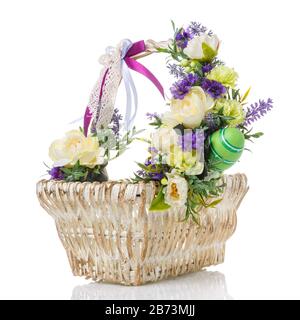 Osterkorb mit hellen Blumen, Lavendel und farbigen Bändern verziert. Isoliert auf weißem Hintergrund Stockfoto