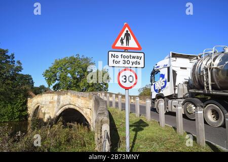 LKW, der keinen Fußraum für Fußgänger in vorausfahrender Straße passiert, Warnschild auf der Brücke, die den Fluss derwent in sutton auf derwent united überquert Stockfoto