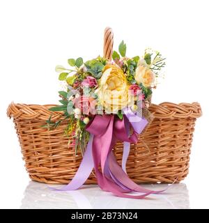 Korbkorb mit original floralem Dekor und langen farbigen Bändern. Isoliert auf weißem Hintergrund Stockfoto