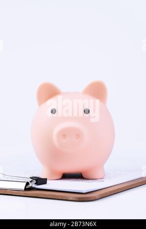 Finanzklage - Piggy Bank, wunderschönes rot-weißes Holzhausmodell auf weißem Hintergrund, spart Geld beim Kauf von Versicherungen, Nahaufnahme, Kopierplatz. Stockfoto