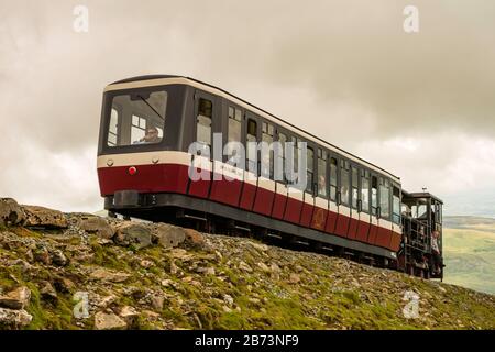 Diesellokomotive "Yeti" (1986) treibt eine Touristenbahn die Snowdon Mountain Railway hoch und geht auf den Gipfel des Mount Snowdon, Wales, Großbritannien. Stockfoto