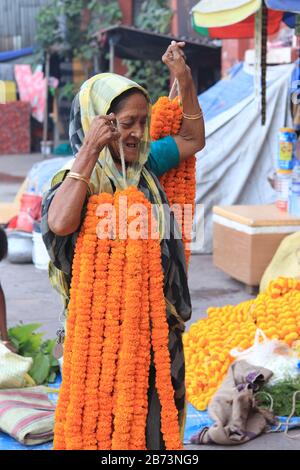 Indianerin hält marigalte Blumenkette Stockfoto