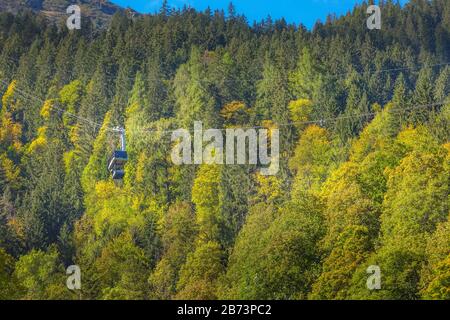 Lauterbrunnen, Schweiz - 10. Oktober 2019: Herbstwald und blaue Murrenbahn in Schweizer Alpen, Jungfrau Region Stockfoto