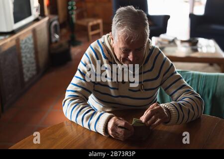 Ein Mann, der zu Hause am Tisch sitzt und sein Geld auszählt Stockfoto