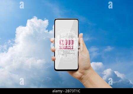 Hintergrundkonzept für Cloud-Computing-Technologie. Mockup Handy mit Cloud Services in Word Tag auf Smartphone-Bildschirm mit blauem Himmel und weißen Wolken Stockfoto