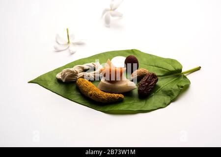 Hindu Puja mit Betelblatt, Supari, Janeu, Mandel, Datteln, Kurkuma, getrockneter Kokosnuss und Zackenbarsch mit 1 Rupie-Münze. Wichtiger Punkt in vedischen Ritualen. sele Stockfoto