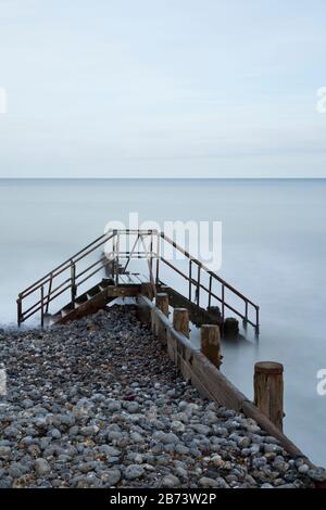 Metallstufen, die über einer Groyne an einem Strand errichtet wurden Stockfoto