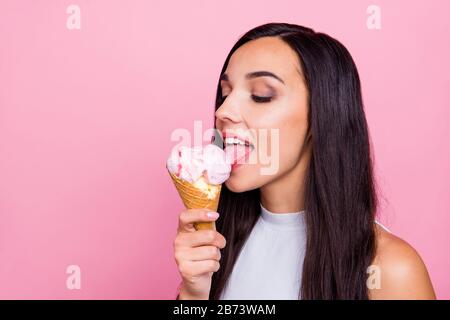 Nahporträt von ihr hübsch aussehende liebenswürdig attraktive glamouröse fröhliche Dame, die den liebsten Eisgeschmack isoliert leckt Stockfoto