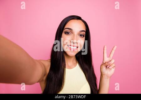 Selbstporträt von ihr hübsch aussehendes süßes attraktives winsome prächtiger Glanz fröhliches fröhliches Mädchen, das V-Zeichen isoliert über rosafarbenem Pastell zeigt Stockfoto