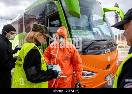 Kudowa Zdroj, Polen. März 2020. Polnische Grenzpolizisten in Schutzanzügen führen am 13. März 2020 am Grenzübergang Nachod-Kudowa Zdroj zwischen Polen und Tschechien medizinische Kontrollen und Temperaturmessungen von aus dem Ausland kommenden Fahrern und Passagieren durch, wegen Bedenken hinsichtlich der Ausbreitung des neuen Coronavirus. Credit: David Tanecek/CTK Photo/Alamy Live News Stockfoto