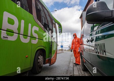 Kudowa Zdroj, Polen. März 2020. Polnische Grenzpolizisten in Schutzanzügen führen am 13. März 2020 am Grenzübergang Nachod-Kudowa Zdroj zwischen Polen und Tschechien medizinische Kontrollen und Temperaturmessungen von aus dem Ausland kommenden Fahrern und Passagieren durch, wegen Bedenken hinsichtlich der Ausbreitung des neuen Coronavirus. Credit: David Tanecek/CTK Photo/Alamy Live News Stockfoto