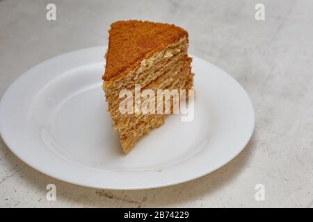 Stück Honigkuchen auf weißem Teller. Minimalismus. Stockfoto