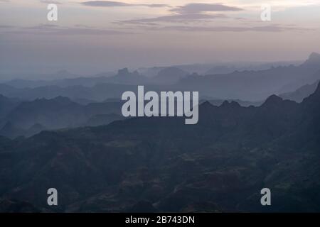 Blick auf die Hazy Simien Mountains am frühen Morgen mit verstreuten Wolken über dem Kopf, Amhara Region, Äthiopien Stockfoto