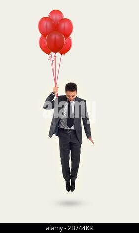 Geschäftsmann fliegt mit Luftballons auf abstraktem Hintergrund mit Kopierraum. Erfolgskonzept und Opportunity-Konzept. Stockfoto