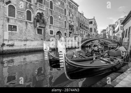 Schöne Schwarz-Weiß-Sicht auf typische Gondeln, die in einem Venetianischen Kanal, Fondamenta dei Preti, Venedig, Italien, geparkt sind Stockfoto