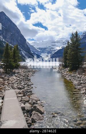 Mount fairview, teilweise gefrorener See, mit Spiegelung im Wasser. Lake Louise Banff National Park, Alberta Canada. Stockfoto