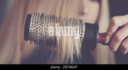 Runde bürsten Kämme langes blondes Haar closeup Stockfoto