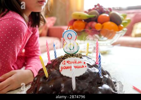 Geburtstagstorte mit Nummer 8. Das Mädchen wartet auf die Beleuchtung von Kerzen. Weicher Fokus, Hintergrund. Worte: Alles gute zum Geburtstag! Stockfoto