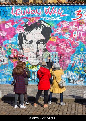 PRAG-13. März:Trotz der Reisebeschränkungen von Covid-19 in Tschechien kommen Touristen immer noch aus der ganzen Welt. Touristen, die mit Lennon fotografieren Stockfoto