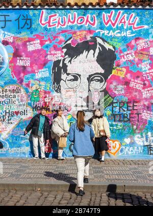 PRAG-13. März:Trotz der Reisebeschränkungen von Covid-19 in Tschechien kommen Touristen immer noch aus der ganzen Welt. Touristen, die mit Lennon fotografieren Stockfoto