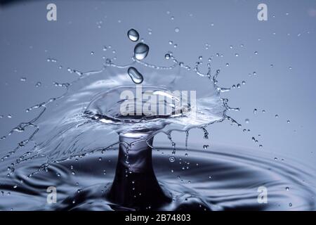 Wassertropfen Zusammenstoß auf einem blauen Hintergrund. Abstrakte klare Natur Hintergrund Stockfoto