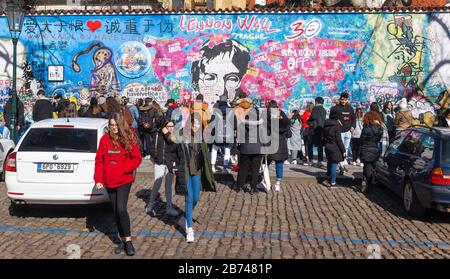 PRAG-13. März:Trotz der Reisebeschränkungen von Covid-19 in Tschechien kommen Touristen immer noch aus der ganzen Welt. Touristen, die mit Lennon fotografieren Stockfoto