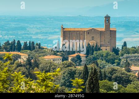 Santi Giusto e Clemente (auch San Giusto oder San Giusto Nuovo genannt), eine alte Kirche in Volterra, Toskana, Italien, mit toskanischer Landschaft dahinter. Stockfoto