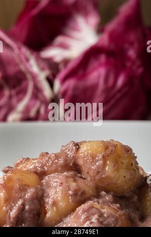 Glutenfreie Kartoffelklöße mit Radicchio Sauce und Walnüssen. Stockfoto