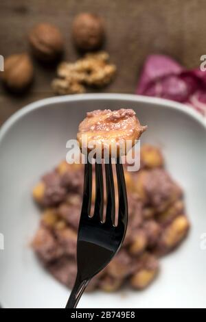 Glutenfreie Kartoffelklöße mit Radicchio Sauce und Walnüssen. Stockfoto