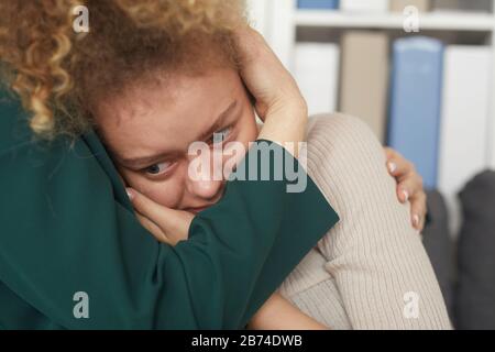 Nahaufnahme einer traurigen Frau, die weinte, während ihr Freund sie umarmte und tröstete Stockfoto