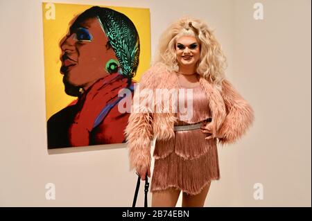 Kitty Scott Claus mit dem Gemälde "Damen und Herren" (Lurdes Wilhelmina Ross). Eine Sammlung von Gemälden von Drag Queens und Trans Women ist in Andy Warhols neuester Ausstellung Andy Warhol zu sehen. Die Eyal Ofer Galleries, Tate Modern, London. GROSSBRITANNIEN Stockfoto