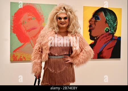 Kitty Scott Claus mit dem Gemälde "Damen und Herren" (Lurdes Wilhelmina Ross). Eine Sammlung von Gemälden von Drag Queens und Trans Women ist in Andy Warhols neuester Ausstellung Andy Warhol zu sehen. Die Eyal Ofer Galleries, Tate Modern, London. GROSSBRITANNIEN Stockfoto