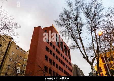 Madrid, Spanien - 8. März 2020: Blick in den unteren Winkel bei Sonnenuntergang auf die Hauptniederlage der Bankinter Bank in Madrid, ein modernes Ziegelgebäude, das von Rafael Mo entworfen wurde Stockfoto