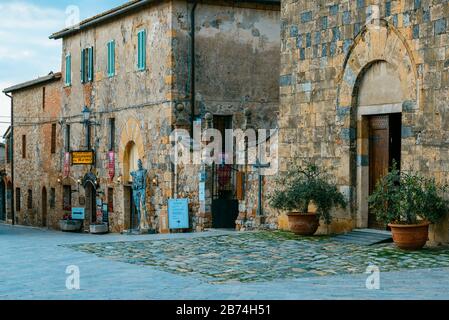 Fassaden des Museo Monteriggioni in Arme und Chiesa di Santa Maria (Kirche Santa Maria) von der Piazza Roma in Monteriggioni, Toskana, Italien Stockfoto