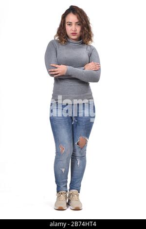 Vollständiges Porträt der Frau, die auf weißem Hintergrund steht, Arme gekreuzt, ernst, Stockfoto