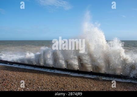 Ein Abschnitt der kürzlich reparierten Meeresverteidigung in Climping Beach, West Sussex, hält das Meer während einer Flut an der Bucht. Stockfoto