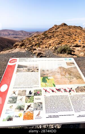 Eine interpetive Tafel und der Blick von Mirador del Risco de las Peñas auf die Kanareninsel Fuerteventura Stockfoto