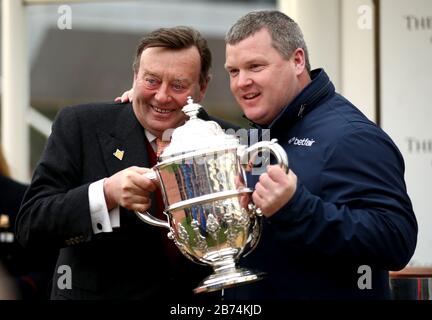 Trainer Gordon Elliott (zweite rechts) wird von Nicky Henderson mit der Trophäe überreicht, nachdem er den Johnny Henderson Grand Annual Challenge Cup Handicap Chase mit Chosen Mate während des vierten Tages des Cheltenham Festivals auf der Cheltenham Racecourse gewonnen hat. Stockfoto