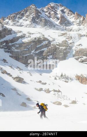 Mylène Jacquemart-Wanderungen über den Black Lake, den Rocky-Mountain-Nationalpark, Colorado. Im Hintergrund sind McHenrys Peak und West Gully (WI4) zu sehen. Stockfoto