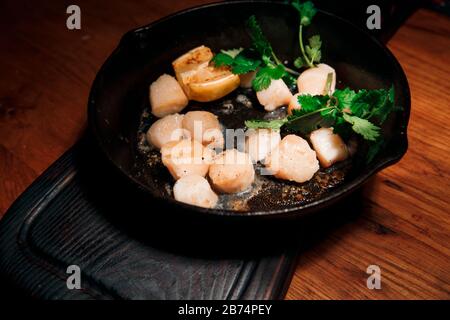 Saftige und köstliche Stücke frittierten Fischfilets. Serviert in einer Pfanne mit Petersilie und Zitrone. Stockfoto