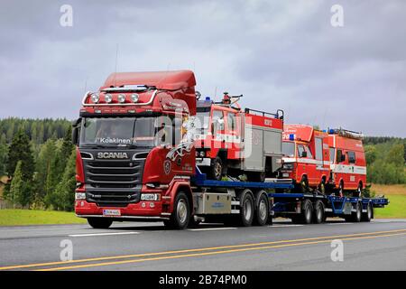 Red Scania R520 Truck Koskisen Konekorjaamo Oy transportiert auf der Autobahn 3 drei alte Feuerwehrfahrzeuge auf Anhänger. Ylöjärvi, Finnland. August 2019. Stockfoto